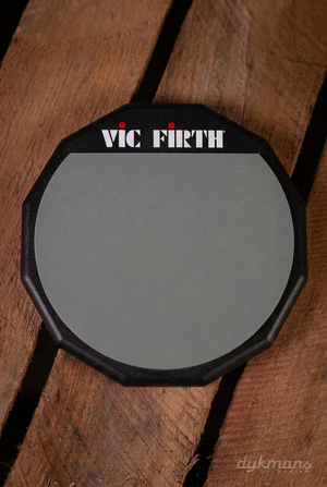 Vic Firth PAD12 enkelzijdige 12 inch oefenpad met grijs rubberen speelvlak op een houten achtergrond